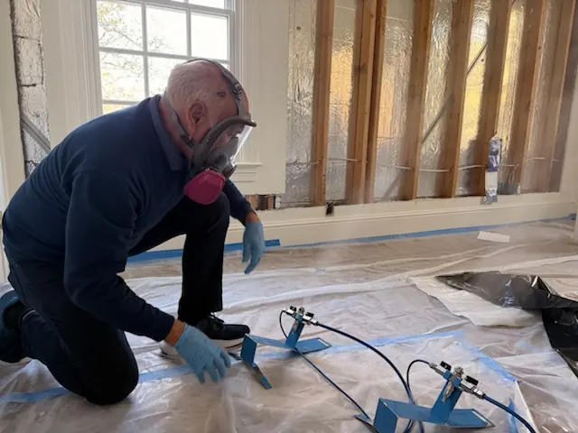 A restoration technician setting drying equipment in a Fort Worth home stripped to the studs